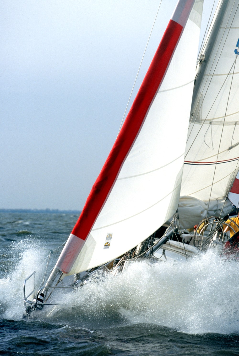 An ATN Gale Sail set over the furled genoa, driving the bow through spray
