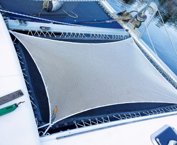 A new white trampoline net with only its four corners tied out, still slack across the middle