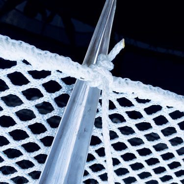 Close-up of a starter knot tied in white lashing line around the edge of a trampoline net