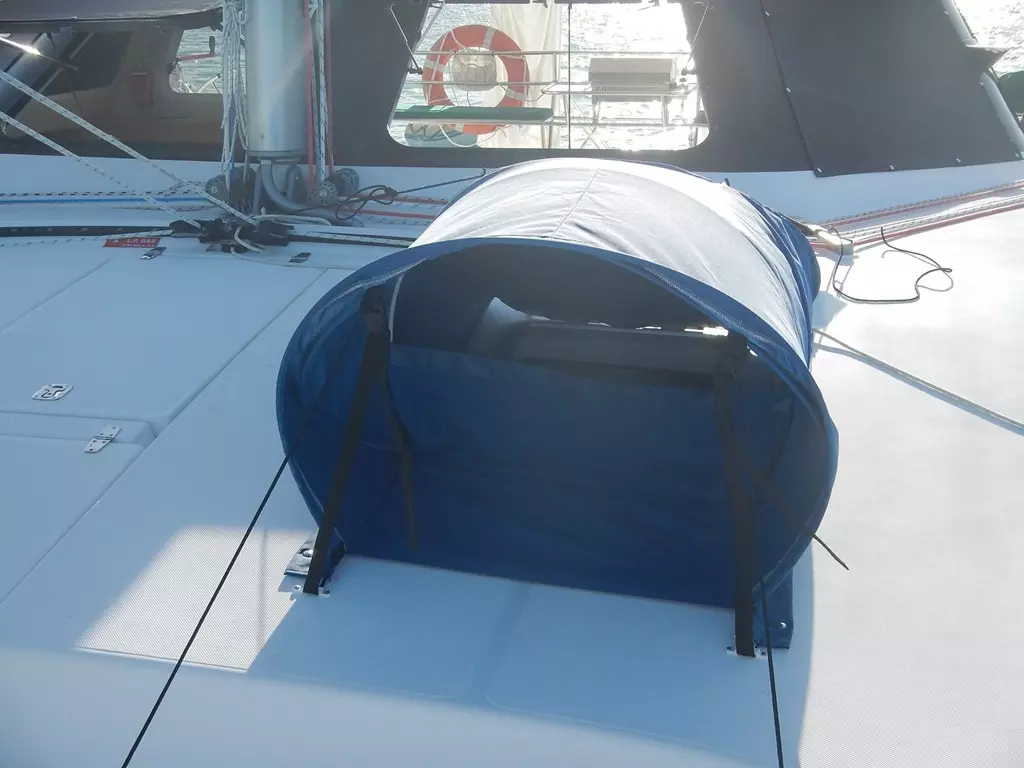 ATN Dorcap canvas hatch vent installed over an open forehatch on a cruising sailboat at anchor, showing the dorade-style intake hood and side panels
